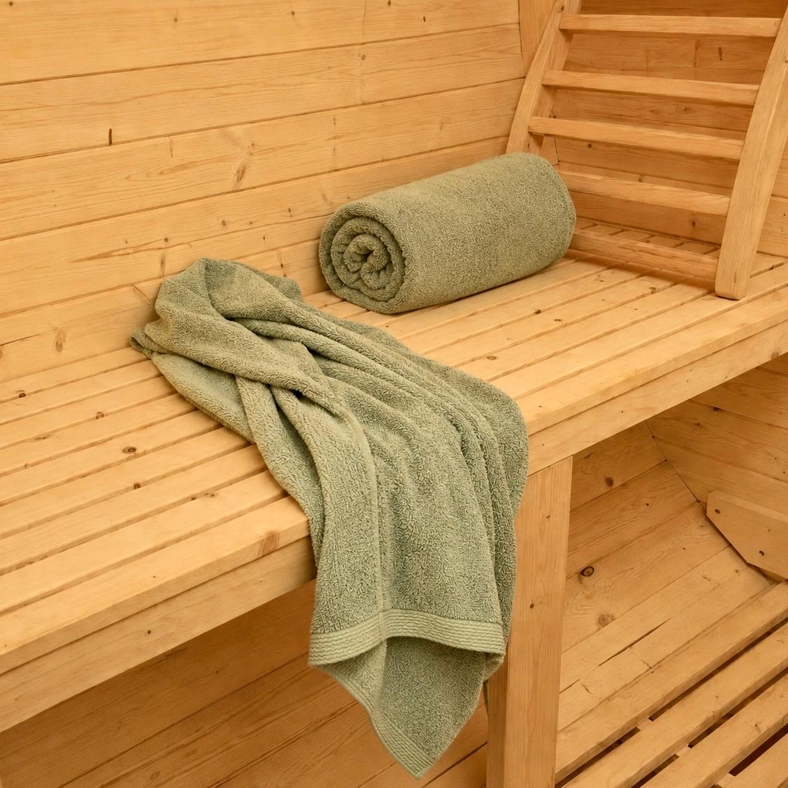 Sage green towel on cedar sauna bench